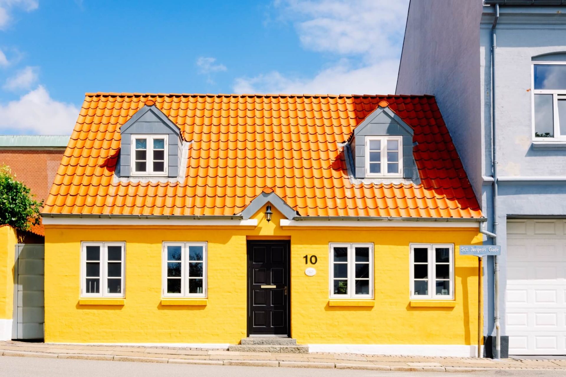 I hjärtat av staden står ett hus som drar till sig uppmärksamhet med sin gula fasad, tak i orange och svarta entréer